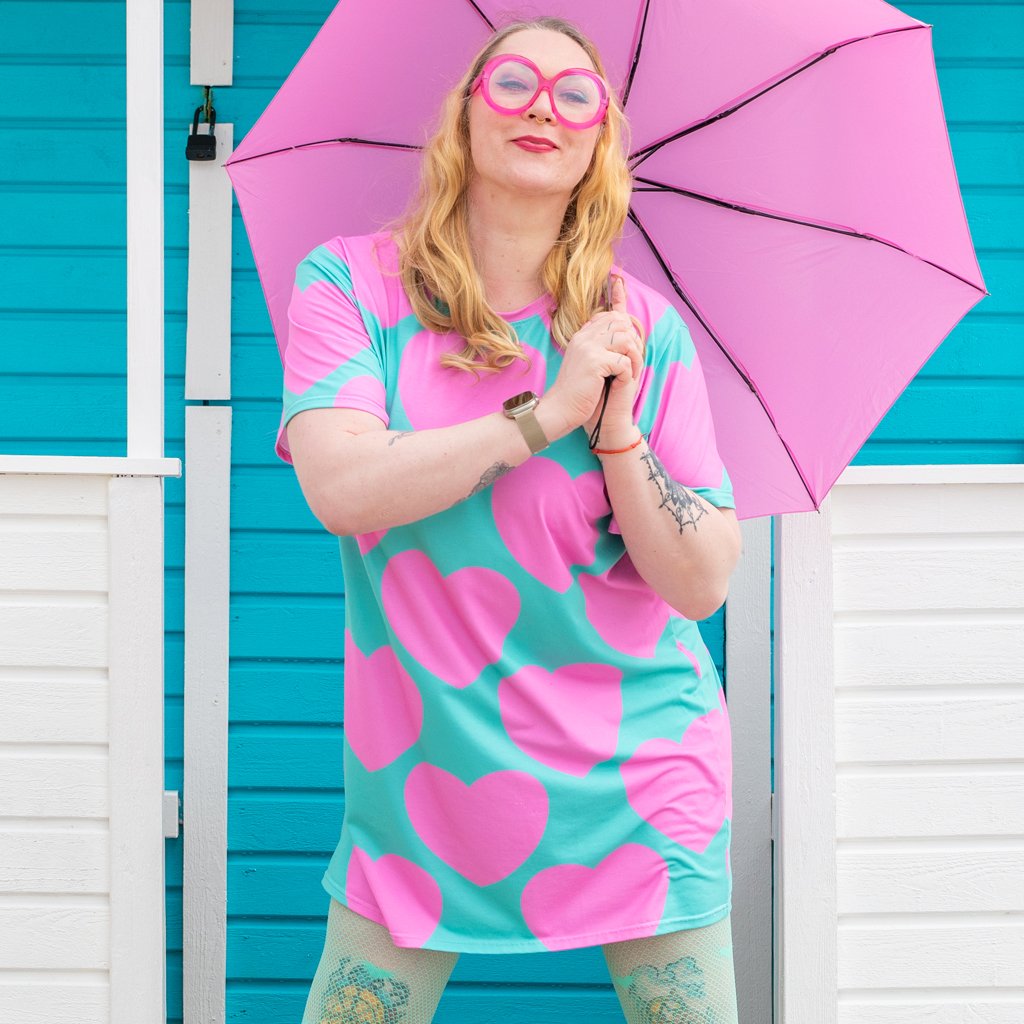 A woman wearing a colorful t-shirt dress by SHALMIAK. Design: ELLIE LOVE pink mint.