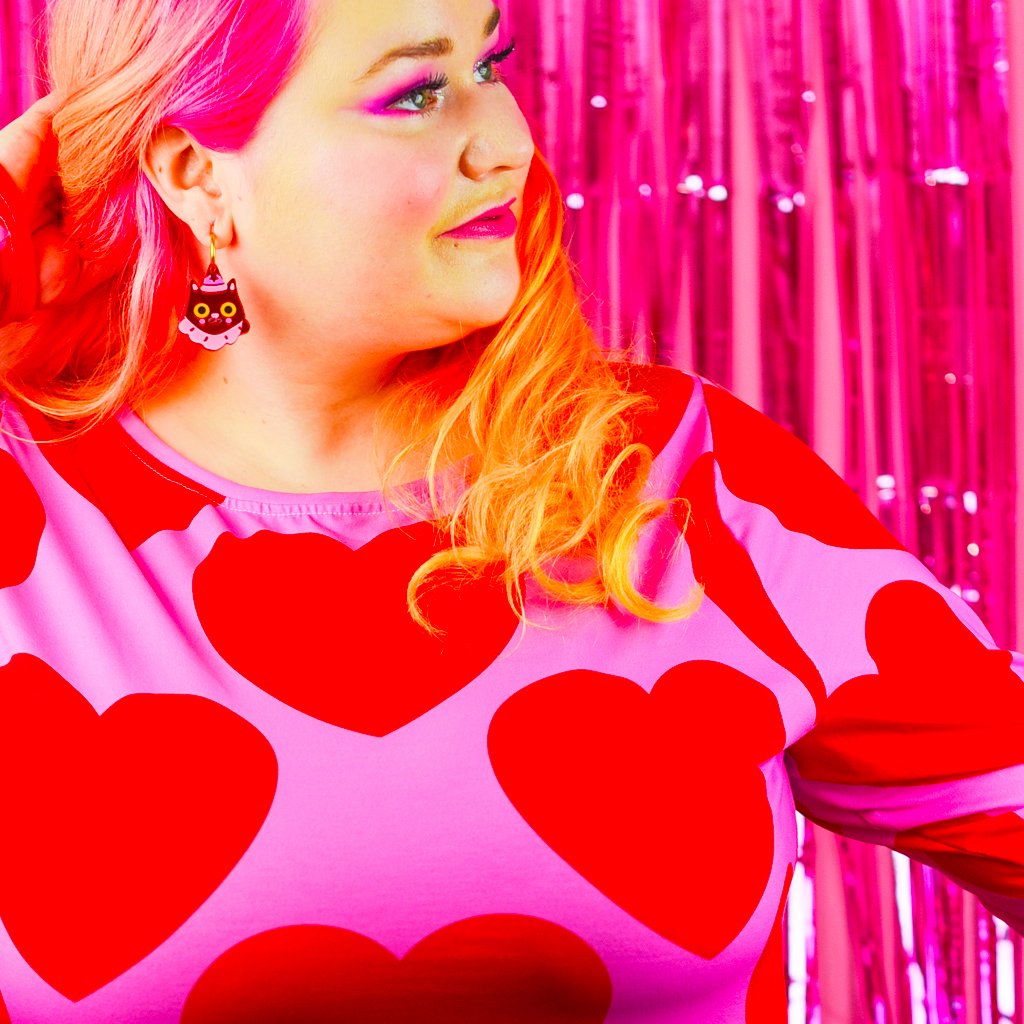 Woman in a bold midi dress with big red hearts. Design: ELLIE LOVE red / SHALMIAK.